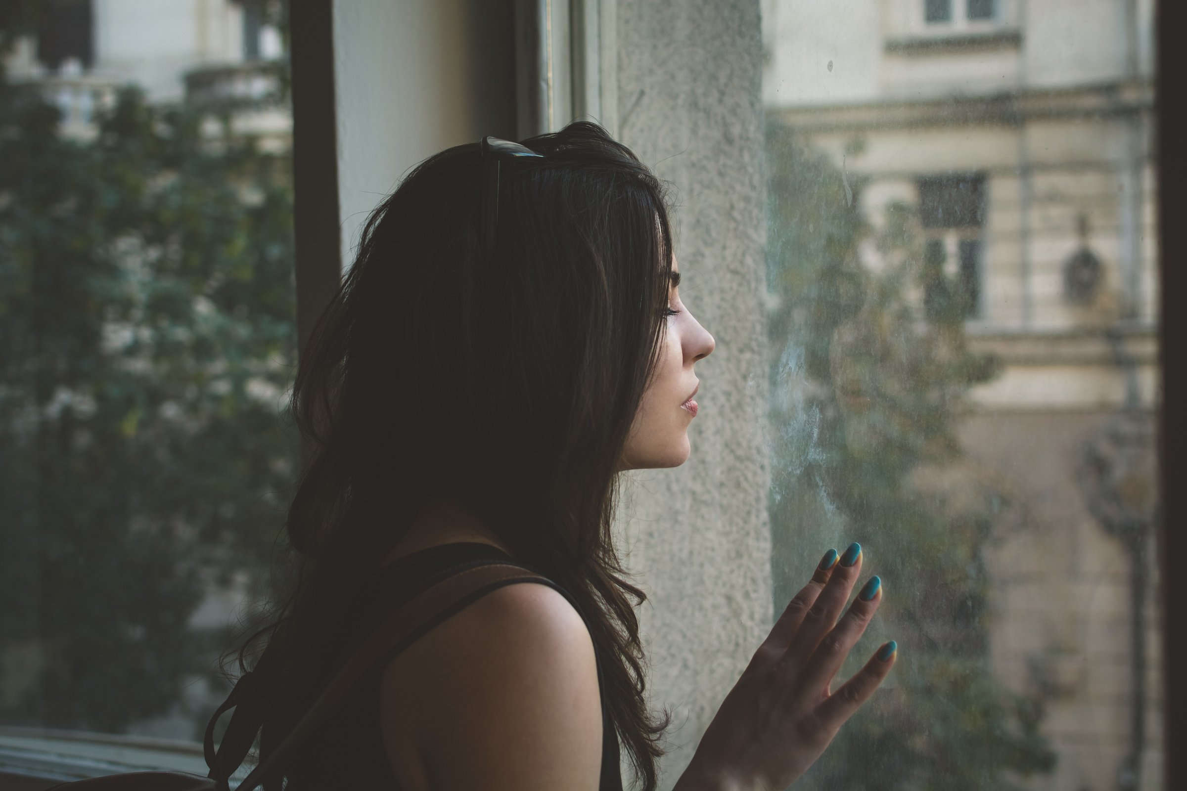 Sad Woman Looking through a Window 